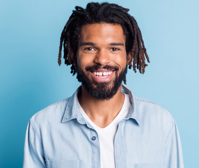 Portrait of nice attractive cheerful guy hipster wearing jeans shirt isolated over bright blue color background.